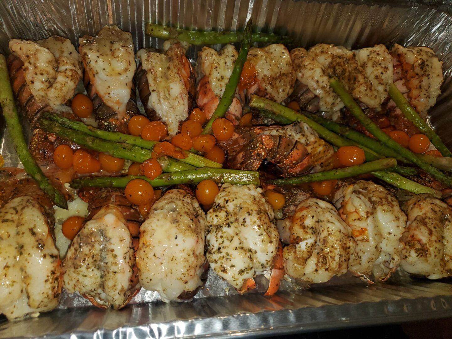 A tray of chicken and vegetables in foil.